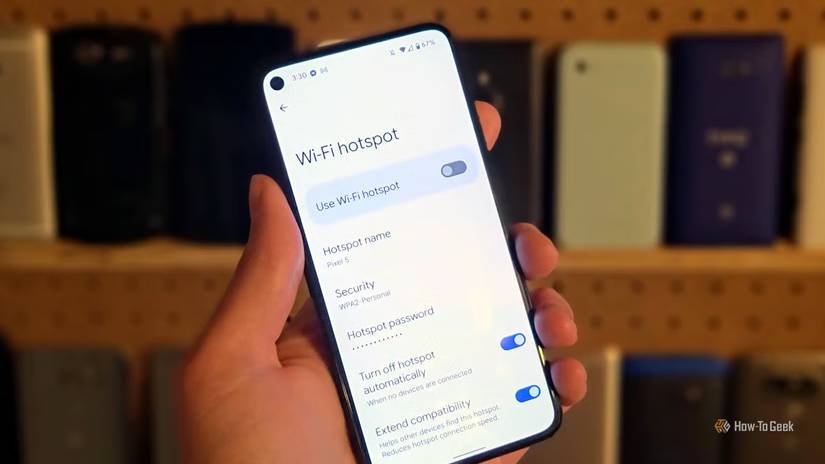 Android スマートフォンを持ち、Android ホットスポット設定ページが表示されている人。