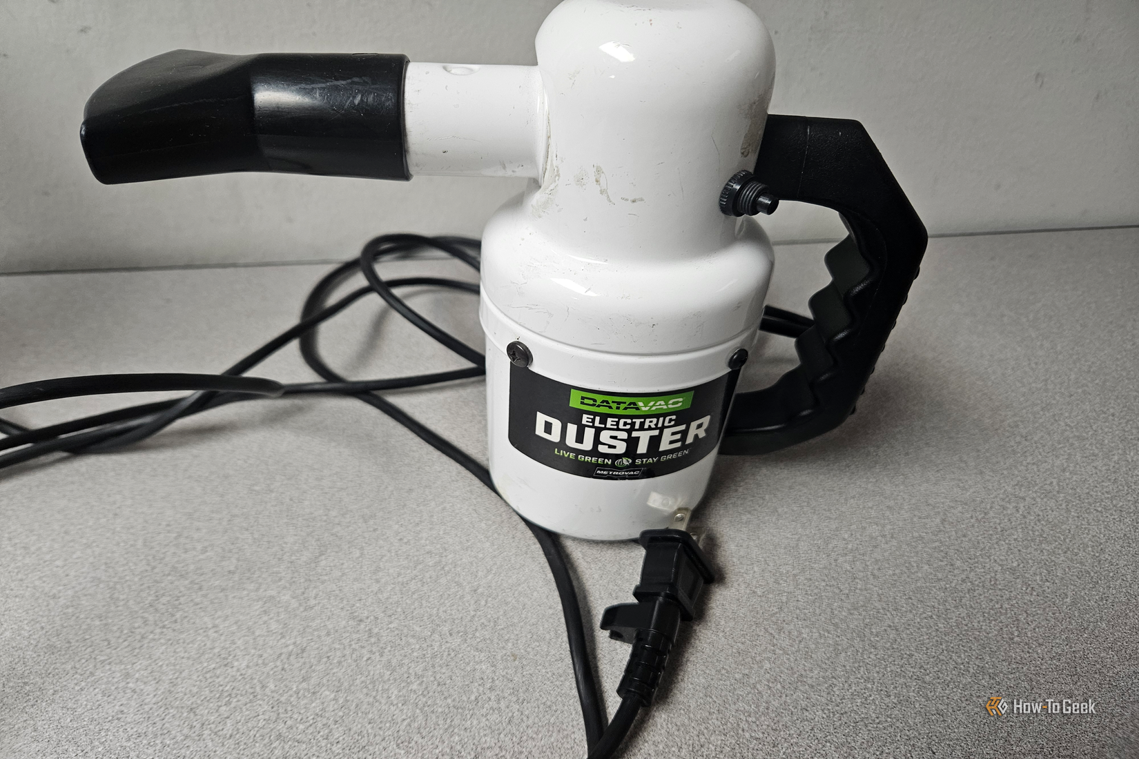 A white DataVac electric duster resting on a surface with its power cord coiled nearby.