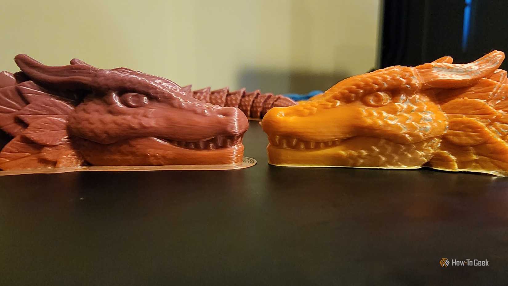 Two 3D-printed dragons face each other with different levels of layer-height detail.