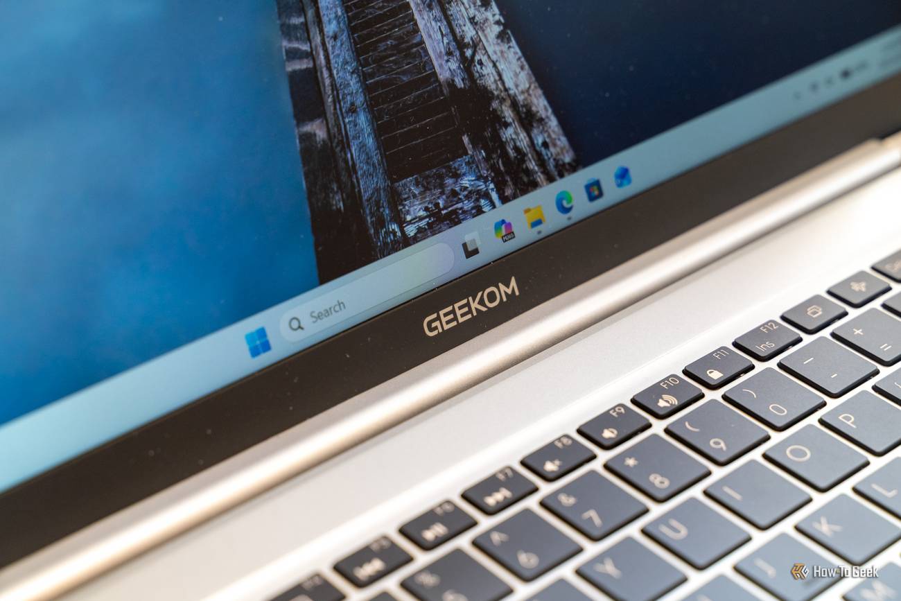 GEEKOM logo on the bottom bezel of the GeekBook M16 display, just above the function keys.