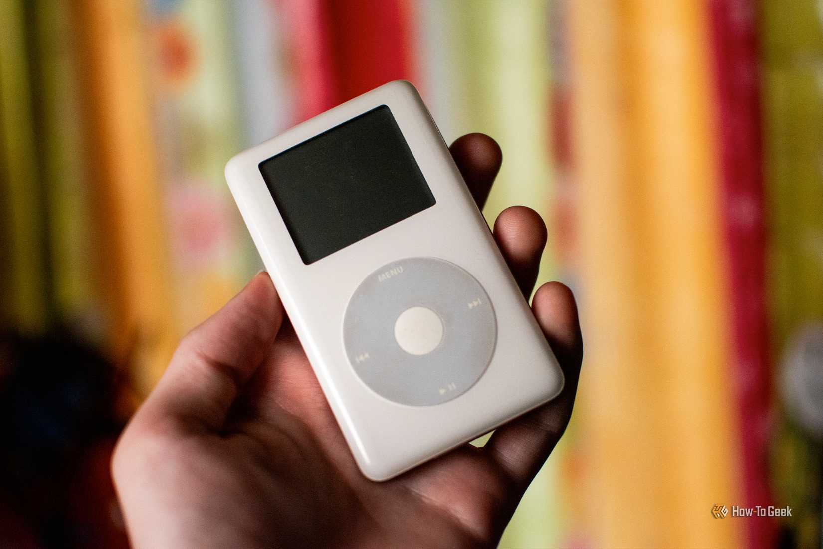 Hand holding an old click wheel Apple iPod.