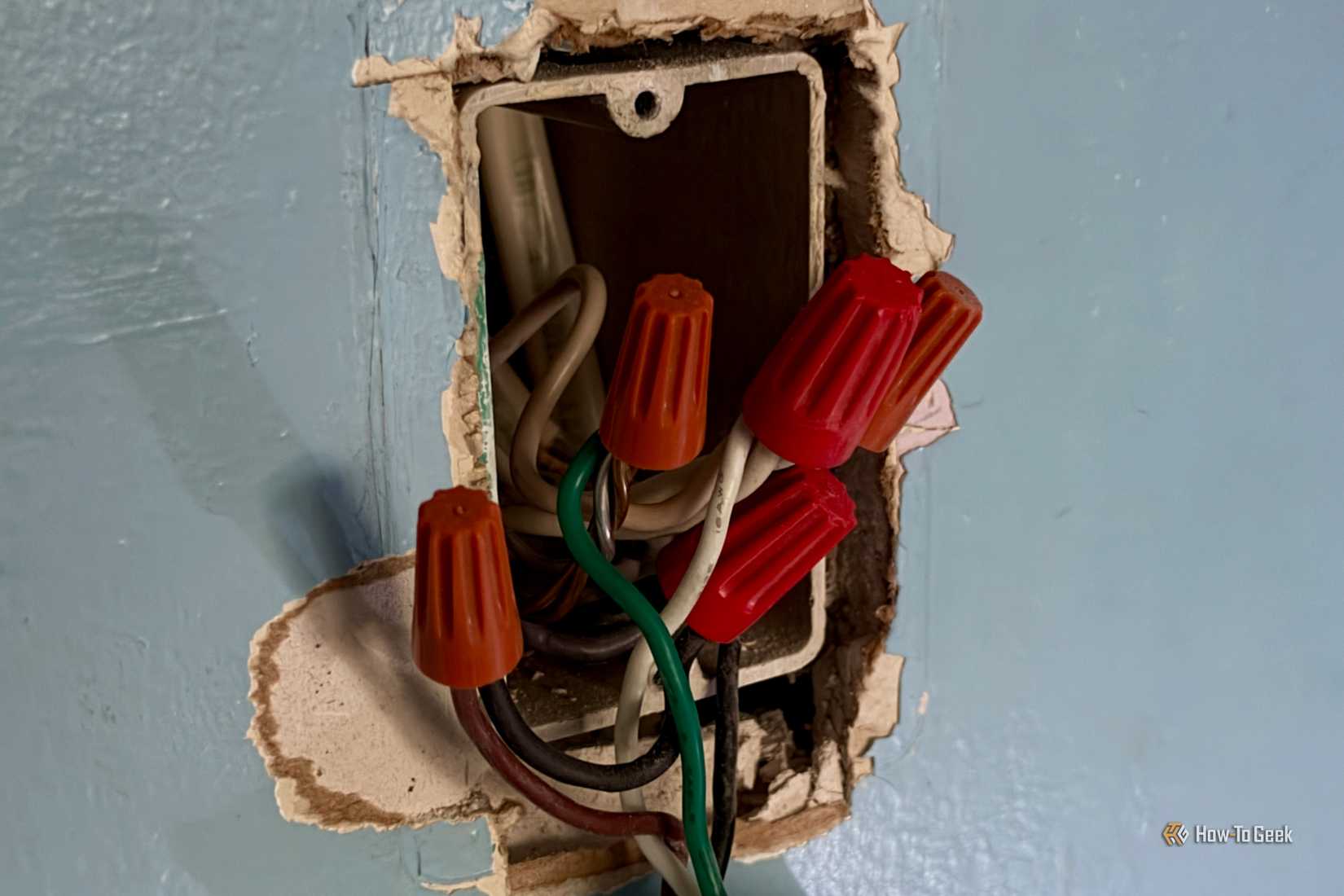 Multiple wires behind a light switch.