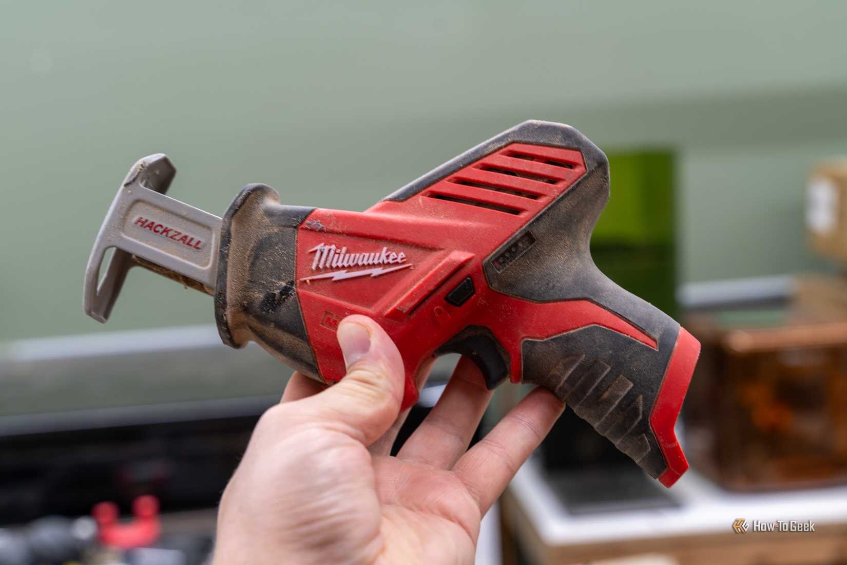 Milwaukee M12 Hackzall resting in an open hand to show its compact size.