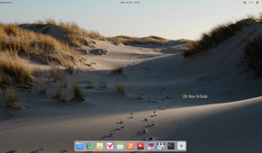 Pantheon desktop on elementary OS with the top panel and macOS-style bottom dock over a sand dune wallpaper.