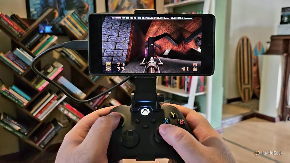A person holds an Android phone in a controller mount running the PC version of Quake.