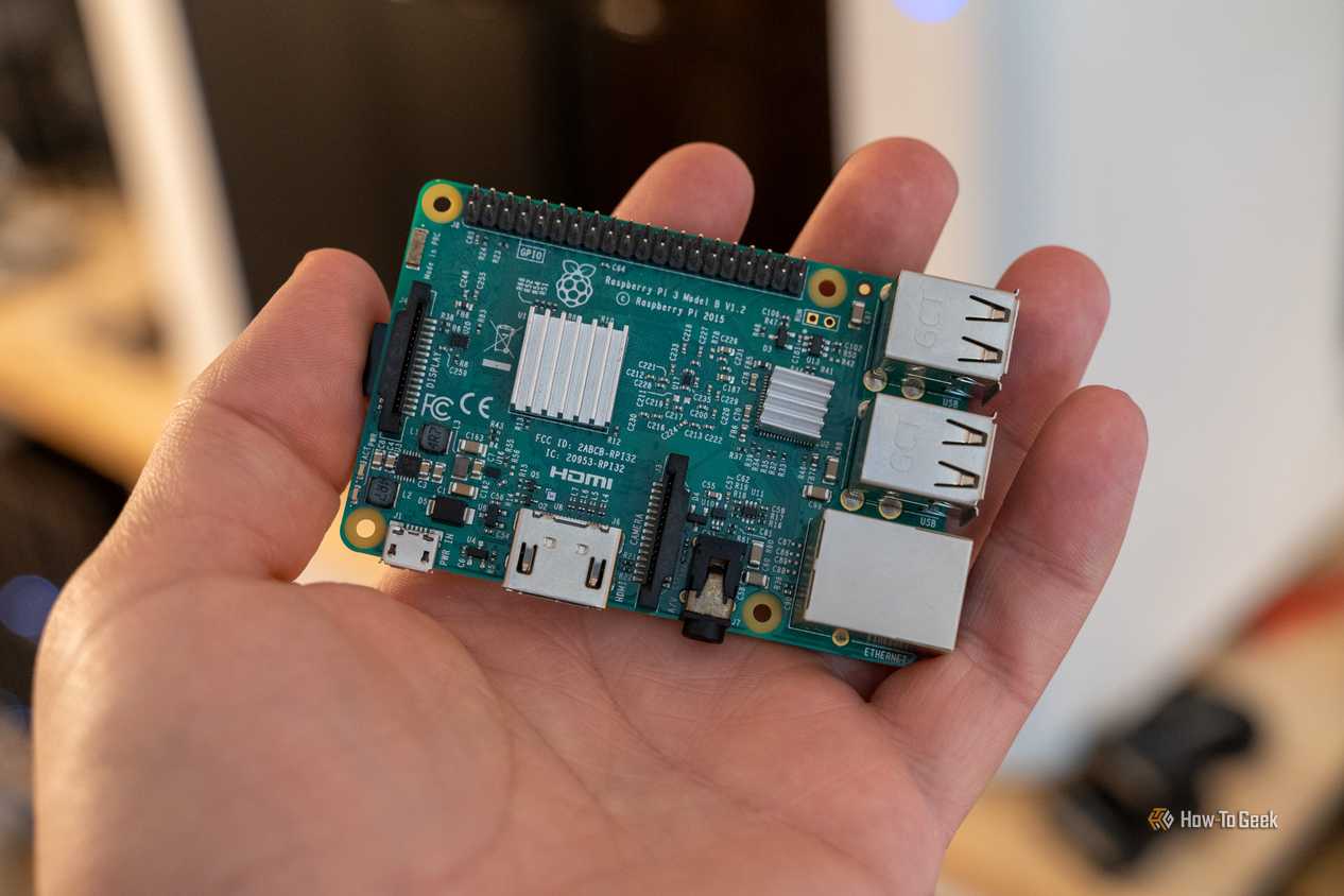 Raspberry Pi 3 Model B resting diagonally on an open palm, with its USB and Ethernet connectors visible.