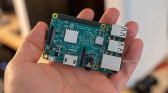 Raspberry Pi 3 Model B resting diagonally on an open palm, with its USB and Ethernet connectors visible.