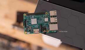 Raspberry Pi 3 Model B resting on a black shelf with its heatsinks and ports visible.