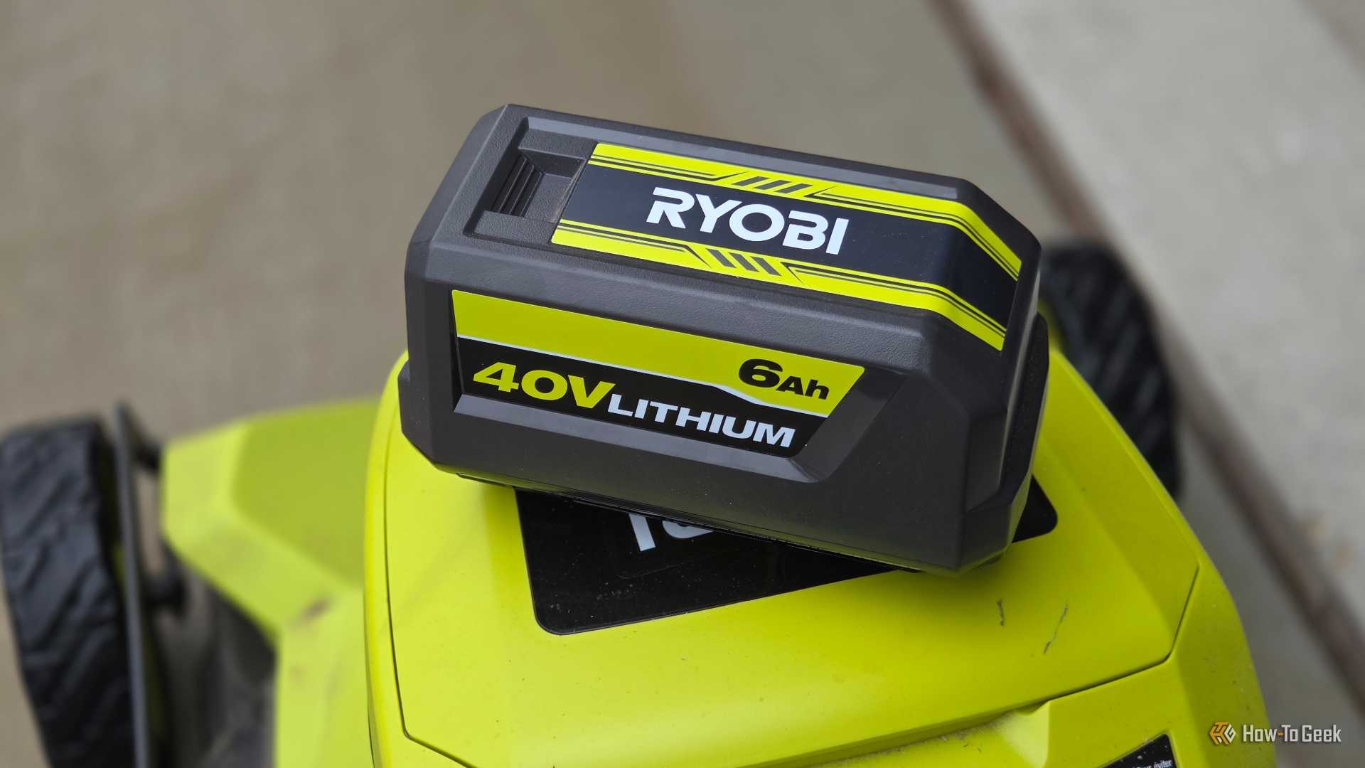 A Ryobi 40v battery on top of a bigger Ryobi machine with wheels.