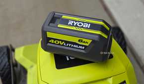 A Ryobi 40v battery on top of a bigger Ryobi machine with wheels.