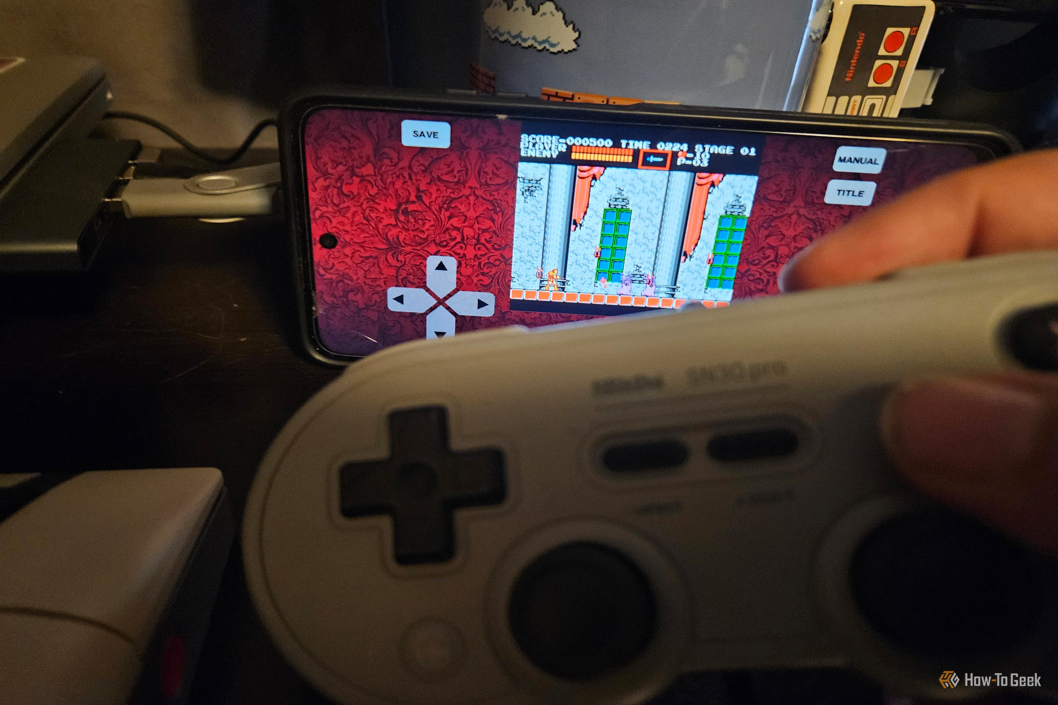 A hand holds a gray 8BitDo controller while playing a Castlevania on an Android screen.