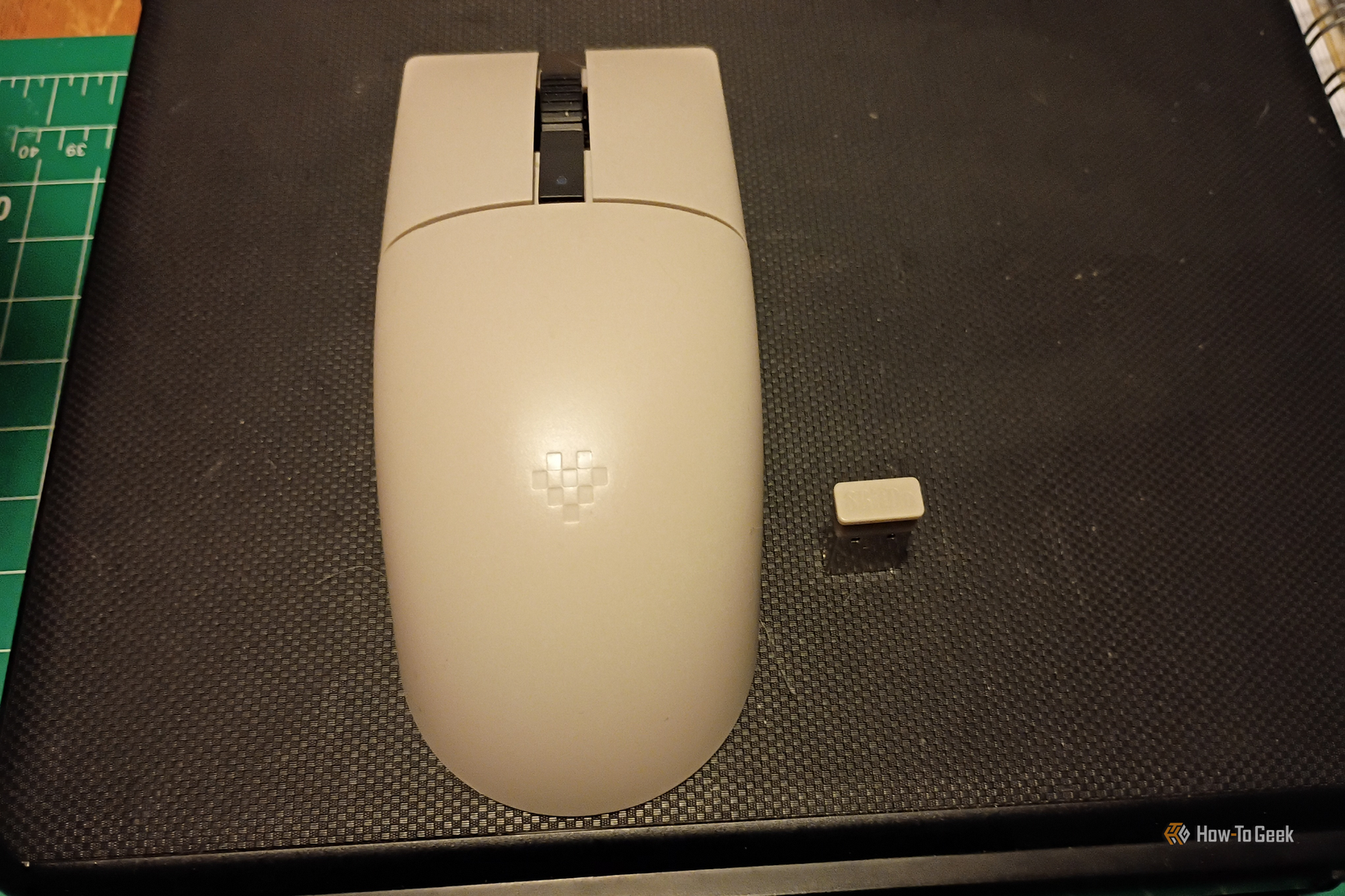 An NES-gray wireless mouse and dongle sit together on a tablet case.