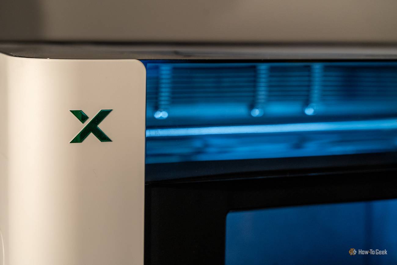 Close-up of the green xTool logo on the O1 Omni's white front housing.